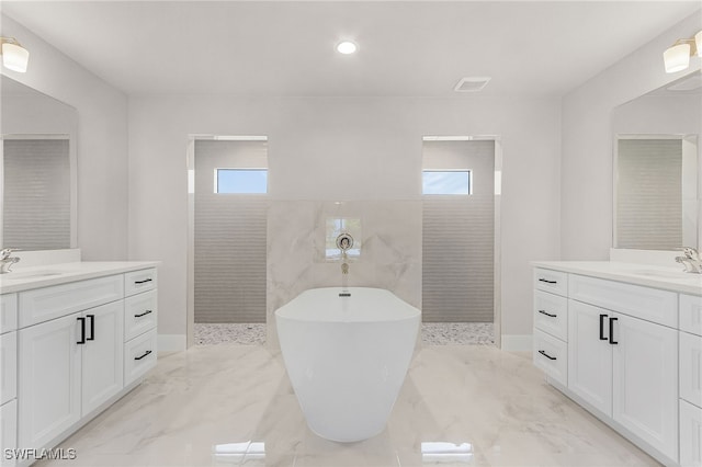 2510 SW 17th Ave, Cape Coral, FL 33914 - bathroom featuring two vanities, a freestanding bath, a walk in shower, marble tiled flooring, and recessed lighting