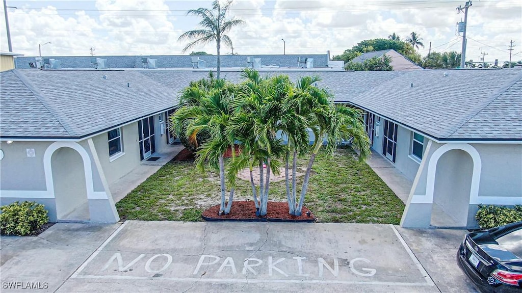 3331 SE 15th Pl, Cape Coral, FL 33904 - exterior space with stucco siding, roof with shingles, and a front yard