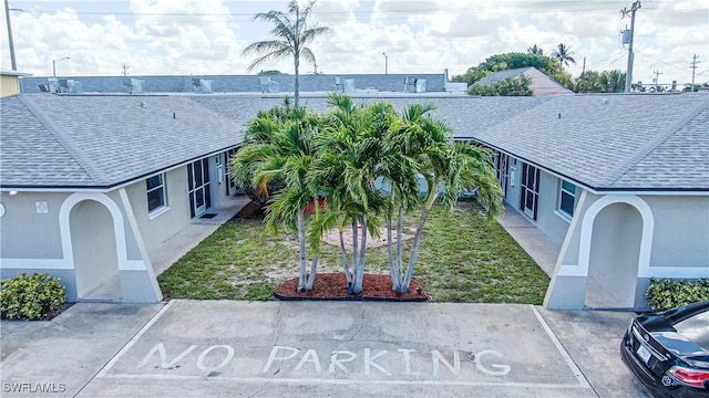 3331 SE 15th Pl, Cape Coral, FL 33904 - exterior space with stucco siding, roof with shingles, and a front yard
