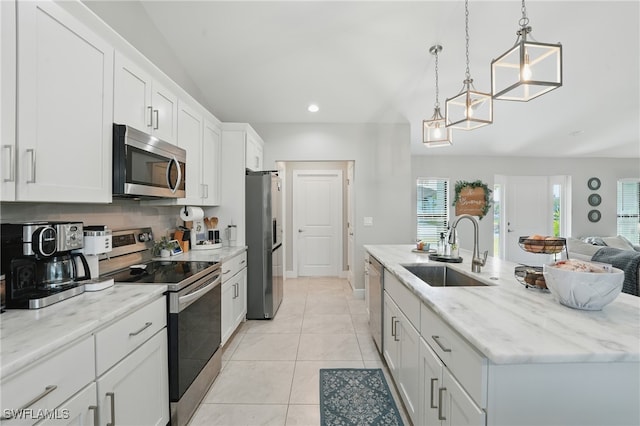 1028 NW 33rd Ave, Cape Coral, FL 33993 - kitchen with stainless steel appliances, a kitchen island with sink, white cabinetry, open floor plan, and light stone counters