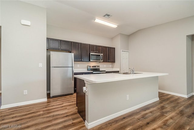 2343 Briarwood St, Punta Gorda, FL 33980 - kitchen with stainless steel appliances, dark wood-style flooring, light countertops, a center island with sink, and vaulted ceiling
