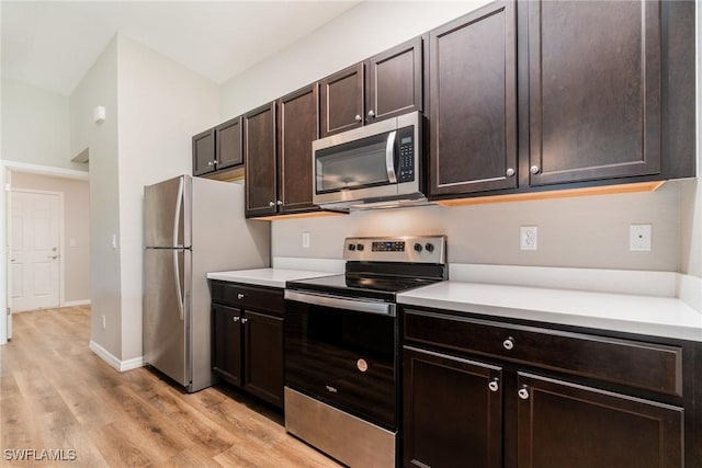 2343 Briarwood St, Punta Gorda, FL 33980 - kitchen with stainless steel appliances, light wood-style flooring, dark brown cabinets, and light countertops