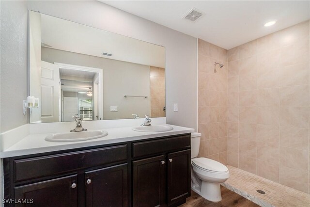 2343 Briarwood St, Punta Gorda, FL 33980 - bathroom with double vanity, a tile shower, wood finished floors, and a ceiling fan