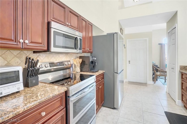 2127 SW 49th Ter, Cape Coral, FL 33914 - kitchen featuring stainless steel appliances, backsplash, light stone countertops, and light tile patterned flooring