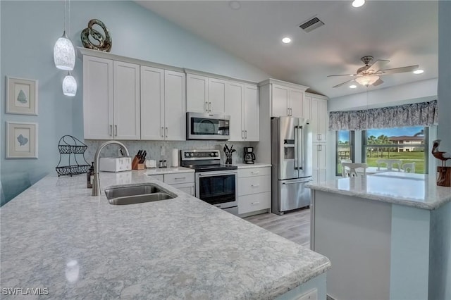 12170 Kelly Greens Blvd Unit 88, Fort Myers, FL 33908 - kitchen with appliances with stainless steel finishes, a peninsula, white cabinets, hanging light fixtures, and tasteful backsplash