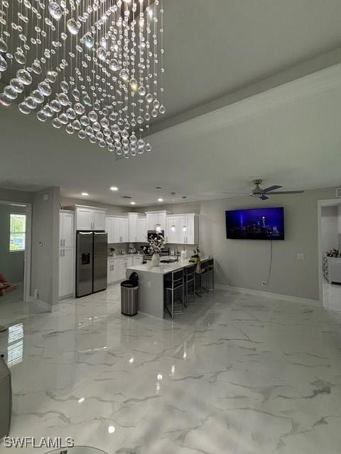 406 W 15th St, Lehigh Acres, FL 33972 - kitchen with stainless steel fridge with ice dispenser, white cabinets, a kitchen breakfast bar, ceiling fan, and recessed lighting
