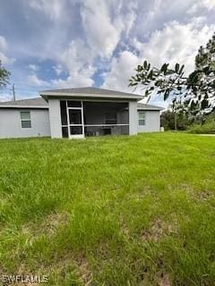 406 W 15th St, Lehigh Acres, FL 33972 - rear view of house with a sunroom and a lawn