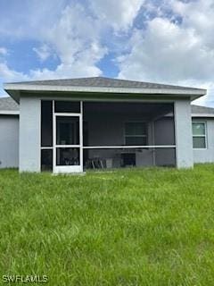 406 W 15th St, Lehigh Acres, FL 33972 - back of house with a sunroom, a lawn, and stucco siding
