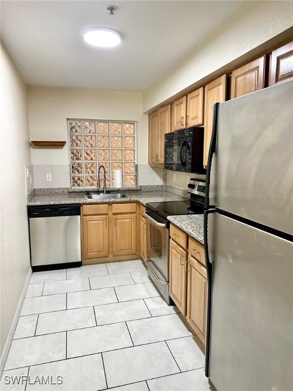 12505 Mcgregor Blvd Unit 204B, Fort Myers, FL 33919 - kitchen with stainless steel appliances, light stone countertops, and light tile patterned floors