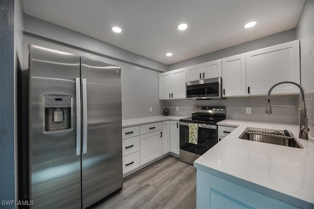 13405 Fox Chapel Ct, Fort Myers, FL 33919 - kitchen with appliances with stainless steel finishes, light wood-type flooring, backsplash, light countertops, and recessed lighting