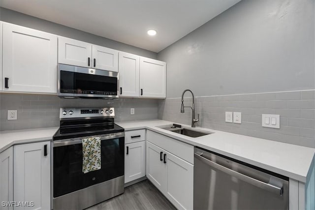 13405 Fox Chapel Ct, Fort Myers, FL 33919 - kitchen with appliances with stainless steel finishes, light countertops, white cabinets, wood finished floors, and tasteful backsplash