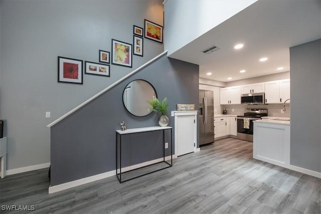 13405 Fox Chapel Ct, Fort Myers, FL 33919 - kitchen with appliances with stainless steel finishes, light wood-type flooring, light countertops, white cabinetry, and recessed lighting