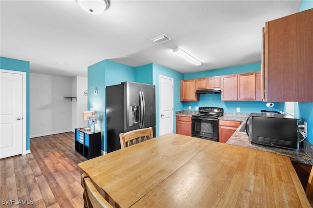 1100 NW 20th St, Cape Coral, FL 33993 - kitchen with electric range, stainless steel fridge, under cabinet range hood, a peninsula, and dark wood finished floors