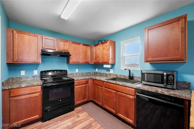 1100 NW 20th St, Cape Coral, FL 33993 - kitchen featuring black appliances, under cabinet range hood, light wood-type flooring, and brown cabinets