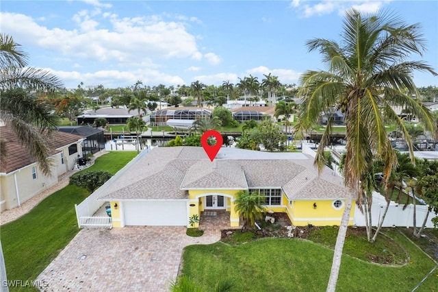 1442 Wellington Ct, Cape Coral, FL 33904 - view of front of property with a garage, driveway, stucco siding, and roof with shingles