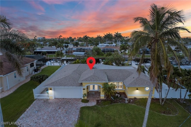 1442 Wellington Ct, Cape Coral, FL 33904 - view of front of home with a garage, decorative driveway, roof with shingles, and stucco siding