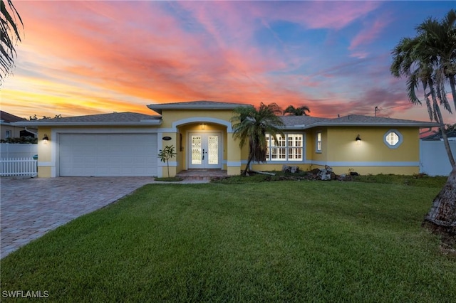1442 Wellington Ct, Cape Coral, FL 33904 - single story home with french doors, stucco siding, an attached garage, and decorative driveway