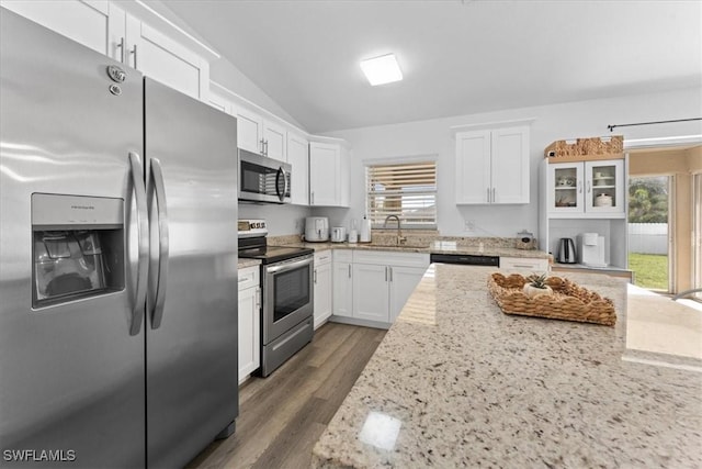 605 SW 18th Ter, Cape Coral, FL 33991 - kitchen featuring stainless steel appliances, vaulted ceiling, white cabinetry, light stone counters, and dark wood finished floors