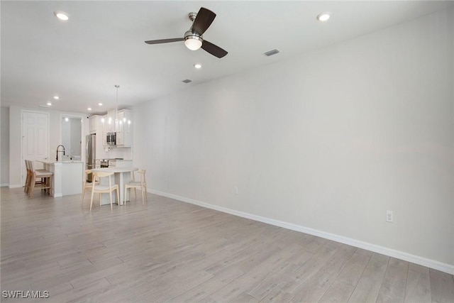 14671 Edgewater Cir, Naples, FL 34114 - living room featuring recessed lighting, light wood-type flooring, a ceiling fan, and a chandelier