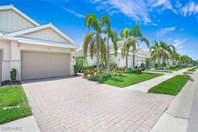 14671 Edgewater Cir, Naples, FL 34114 - view of front facade featuring board and batten siding, a garage, decorative driveway, and a front yard
