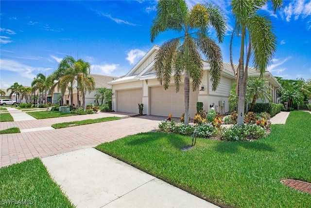 14671 Edgewater Cir, Naples, FL 34114 - view of front facade with decorative driveway, stucco siding, a front yard, and a garage