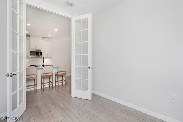 14671 Edgewater Cir, Naples, FL 34114 - empty room with french doors, light wood-type flooring, and recessed lighting