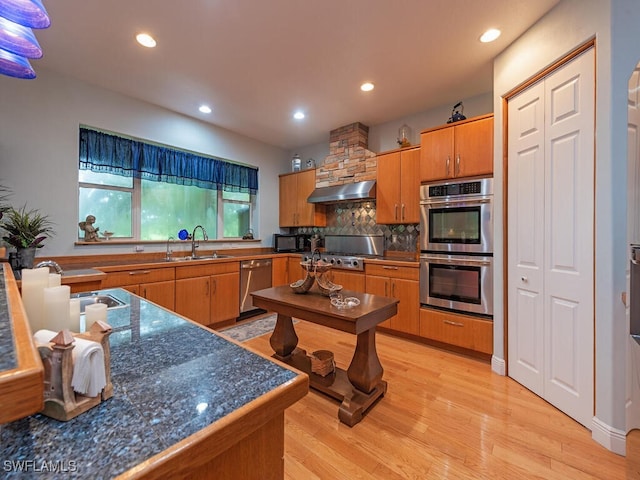 21950 N River Rd, Alva, FL 33920 - kitchen with appliances with stainless steel finishes, exhaust hood, decorative backsplash, light wood-type flooring, and recessed lighting