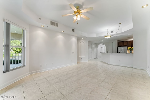 15250 Riverbend Blvd Unit 101, North Fort Myers, FL 33917 - unfurnished living room featuring ceiling fan, a raised ceiling, arched walkways, and recessed lighting