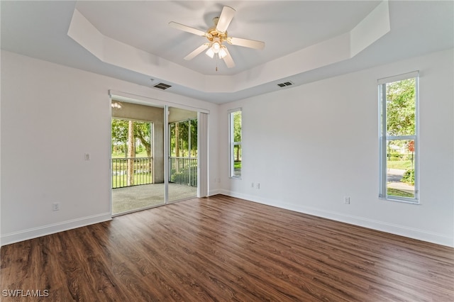 15250 Riverbend Blvd Unit 101, North Fort Myers, FL 33917 - spare room with a tray ceiling, healthy amount of natural light, and dark wood-style floors