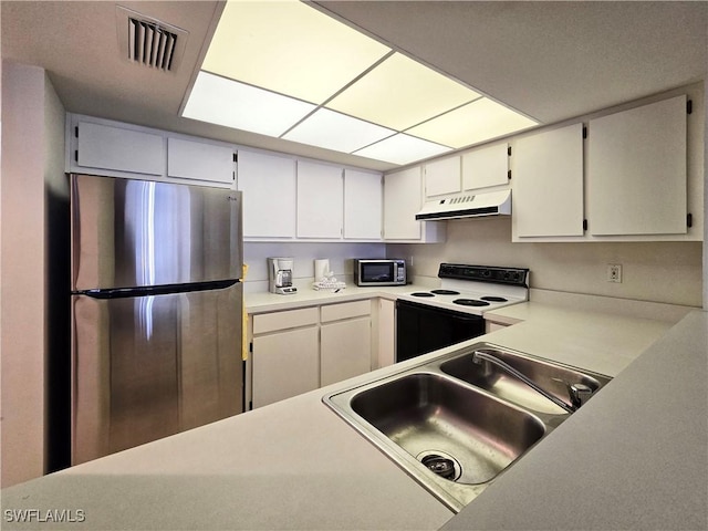 345 Mango St Unit 505, Fort Myers Beach, FL 33931 - kitchen with appliances with stainless steel finishes, under cabinet range hood, light countertops, and white cabinets