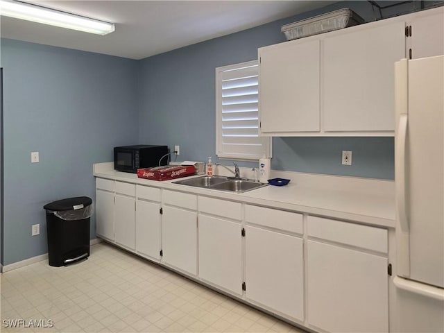 345 Mango St Unit 505, Fort Myers Beach, FL 33931 - kitchen with freestanding refrigerator, light countertops, black microwave, and white cabinets