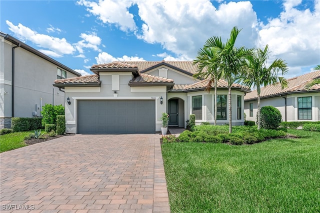 19604 Beechcrest Pl, Estero, FL 33928 - mediterranean / spanish home with decorative driveway, a tile roof, a front yard, an attached garage, and stucco siding