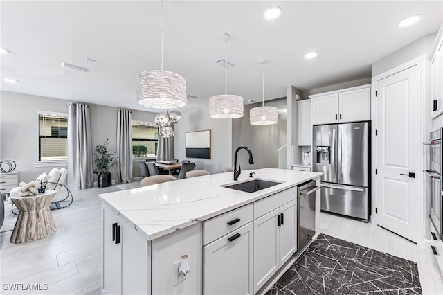 19604 Beechcrest Pl, Estero, FL 33928 - kitchen with appliances with stainless steel finishes, open floor plan, a kitchen island with sink, white cabinetry, and hanging light fixtures