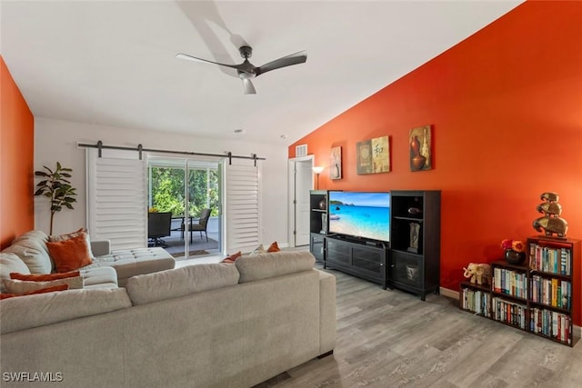 9059 Aegean Cir, Lehigh Acres, FL 33936 - living area featuring a barn door, ceiling fan, wood finished floors, and vaulted ceiling