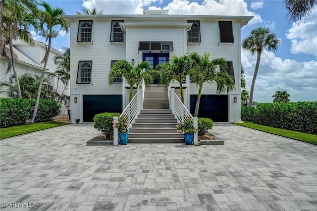 4031 Bayside Rd, Fort Myers Beach, FL 33931 - coastal inspired home featuring stairs, a garage, and decorative driveway