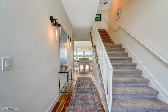 4031 Bayside Rd, Fort Myers Beach, FL 33931 - staircase with wood finished floors and a chandelier