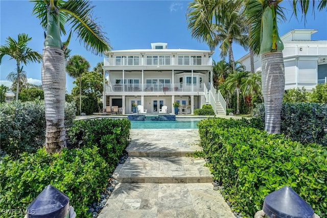 4031 Bayside Rd, Fort Myers Beach, FL 33931 - rear view of property featuring a balcony, stairs, french doors, a patio, and a pool with connected hot tub