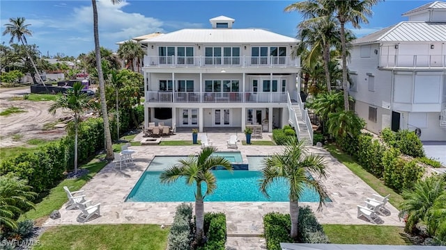 4031 Bayside Rd, Fort Myers Beach, FL 33931 - back of property featuring french doors, a balcony, a patio area, stairway, and an outdoor pool