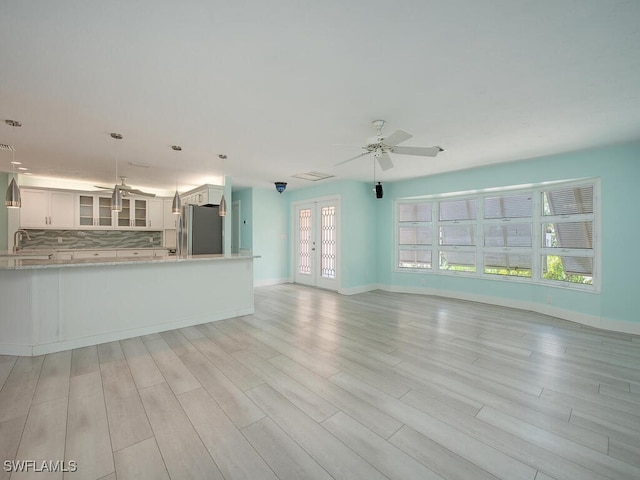 1486 13th Ave N, Naples, FL 34102 - unfurnished living room with a ceiling fan and light wood-style flooring