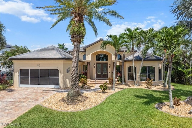 4007 Surfside Blvd, Cape Coral, FL 33914 - mediterranean / spanish-style home with french doors, stucco siding, an attached garage, decorative driveway, and a front yard