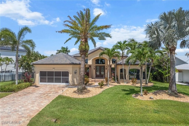 4007 Surfside Blvd, Cape Coral, FL 33914 - mediterranean / spanish-style house with french doors, stucco siding, a garage, and decorative driveway