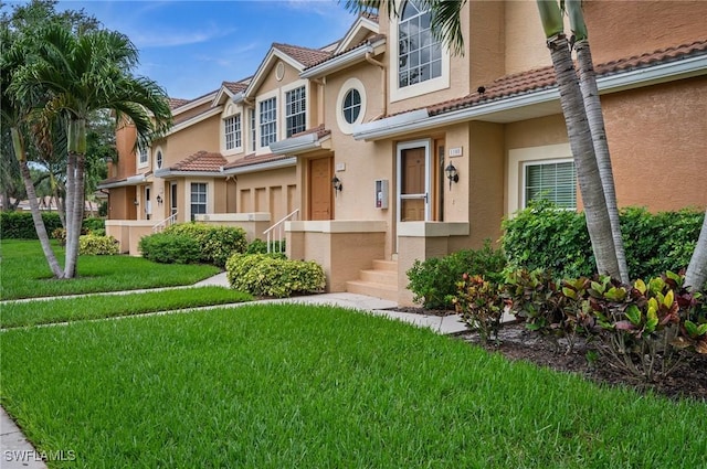 13090 Amberley Ct Unit 1103, Bonita Springs, FL 34135 - townhome / multi-family property with stucco siding, a front yard, and a tile roof