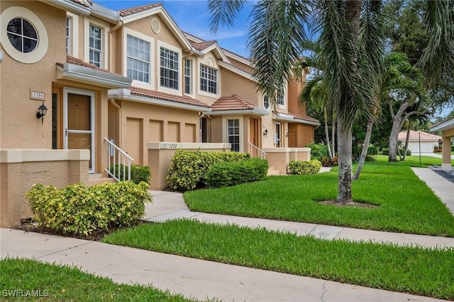 13090 Amberley Ct Unit 1103, Bonita Springs, FL 34135 - townhome / multi-family property featuring stucco siding, a front lawn, a garage, and a tile roof