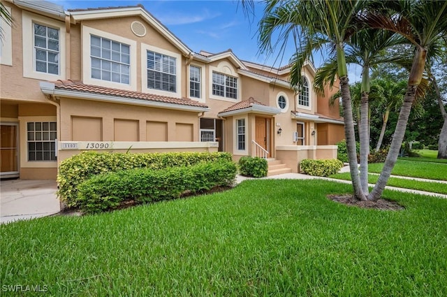 13090 Amberley Ct Unit 1103, Bonita Springs, FL 34135 - townhome / multi-family property featuring stucco siding, a front yard, and a tile roof
