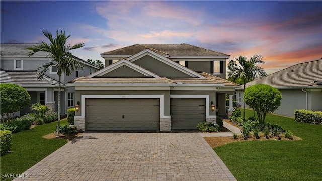 4276 Watercolor Way, Fort Myers, FL 33966 - view of front of property with stucco siding, decorative driveway, stone siding, a yard, and a garage