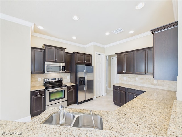 11217 Suffield St, Fort Myers, FL 33913 - kitchen featuring appliances with stainless steel finishes, dark brown cabinetry, light stone countertops, backsplash, and recessed lighting