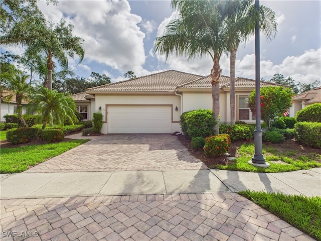 11217 Suffield St, Fort Myers, FL 33913 - mediterranean / spanish-style house featuring a tile roof, decorative driveway, a garage, and stucco siding