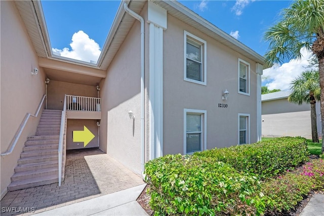 12330 Notting Hill Ln Unit 14, Bonita Springs, FL 34135 - view of side of property featuring stucco siding and stairway