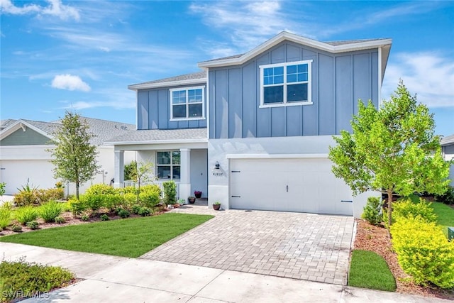 43837 Cattleman Dr, Punta Gorda, FL 33982 - view of front facade with board and batten siding, decorative driveway, an attached garage, roof with shingles, and a front yard