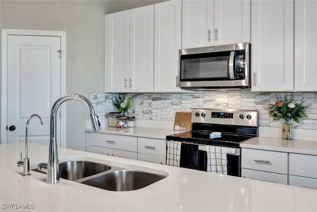 43837 Cattleman Dr, Punta Gorda, FL 33982 - kitchen featuring stainless steel appliances, light countertops, white cabinetry, and tasteful backsplash